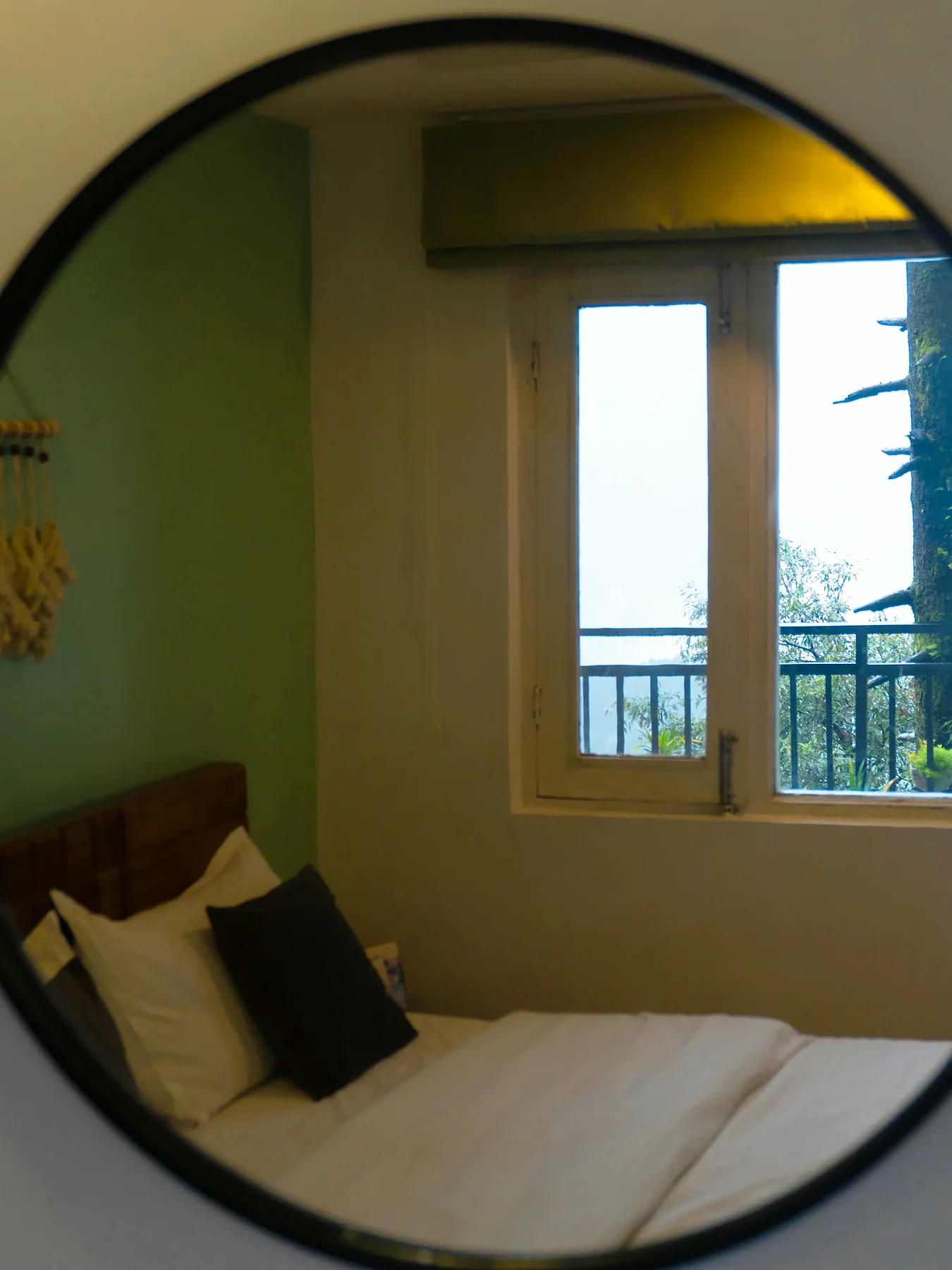 The bed reflected in a round mirror, Fireside Retreat room, The Coverpage Boutique Stays, Mussoorie
